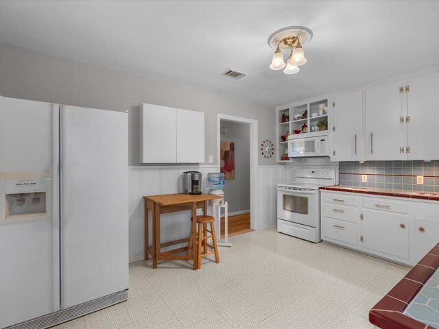110 Marshall St, League City, TX 77573 - kitchen with white appliances, tile countertops, white cabinetry, open shelves, and backsplash