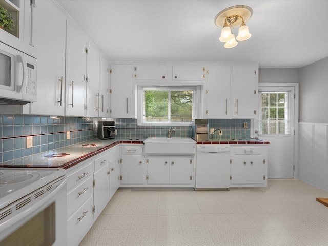 110 Marshall St, League City, TX 77573 - kitchen with white appliances, a sink, white cabinetry, backsplash, and wainscoting