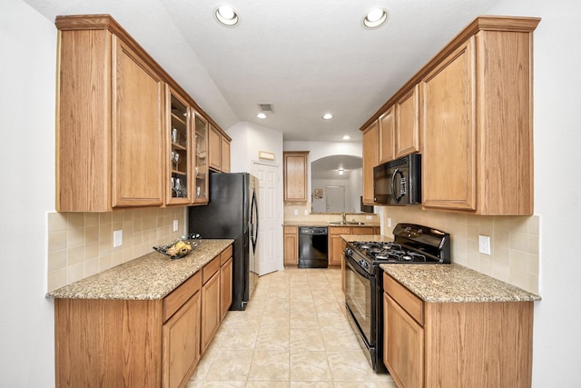 12943 Palm Leaf Ct, Houston, TX 77044 - kitchen featuring black appliances, a sink, backsplash, light stone countertops, and recessed lighting