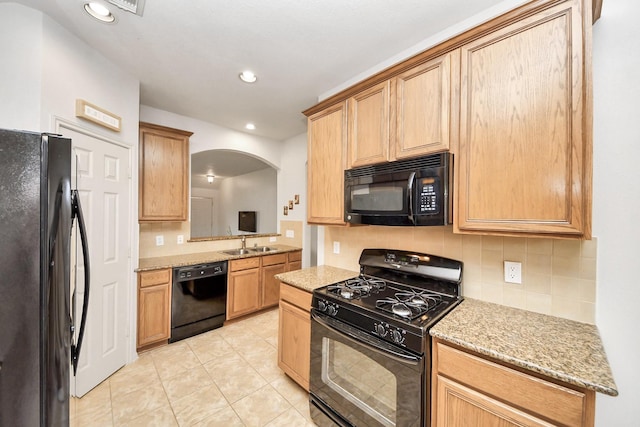 12943 Palm Leaf Ct, Houston, TX 77044 - kitchen with black appliances, arched walkways, decorative backsplash, a sink, and light tile patterned flooring