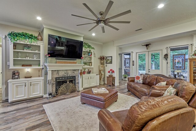 167 Monterrey Rd E, Montgomery, TX 77356 - living area with ceiling fan, wood finished floors, a fireplace with flush hearth, ornamental molding, and recessed lighting