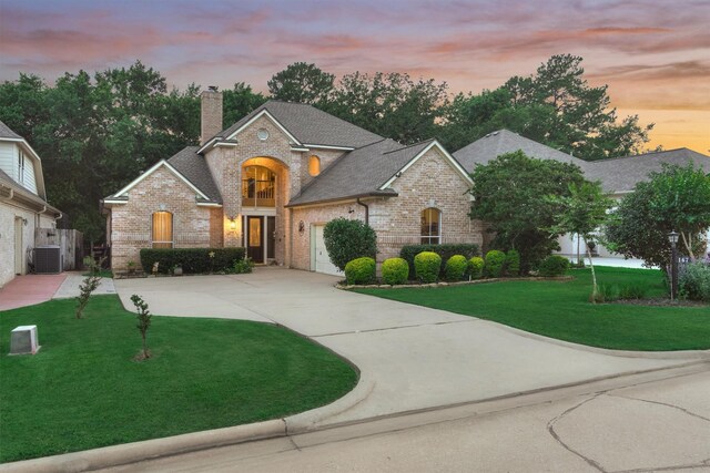 167 Monterrey Rd E, Montgomery, TX 77356 - view of front of home with brick siding, central AC unit, concrete driveway, a chimney, and a front yard