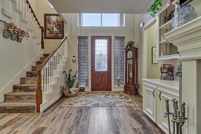 167 Monterrey Rd E, Montgomery, TX 77356 - foyer entrance with stairs, wood finished floors, a towering ceiling, and baseboards