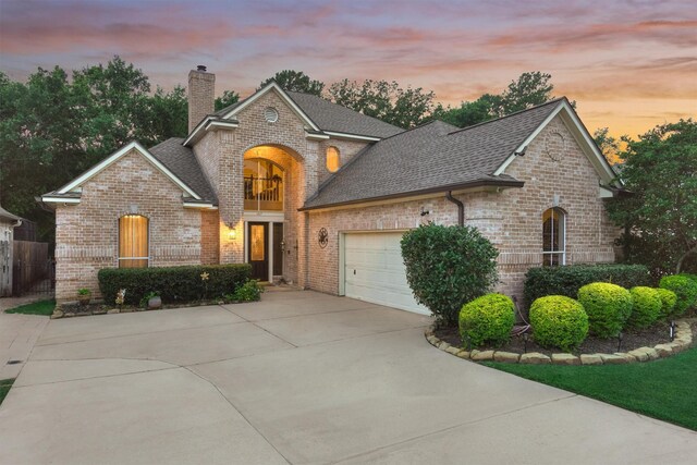 167 Monterrey Rd E, Montgomery, TX 77356 - view of front of property featuring brick siding, concrete driveway, a chimney, and roof with shingles