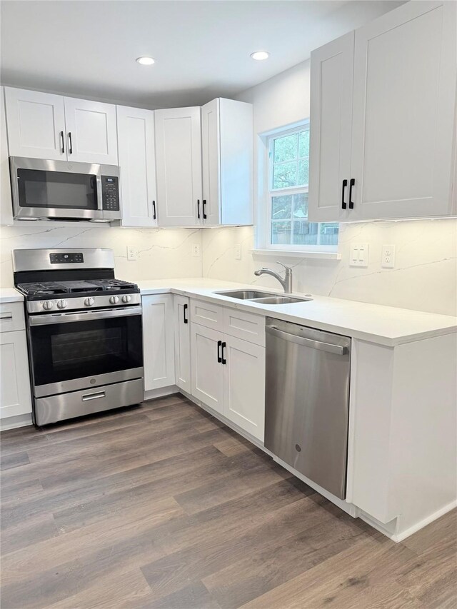 115 Penick Rd, Waller, TX 77484 - kitchen with stainless steel appliances, a sink, decorative backsplash, light countertops, and white cabinets