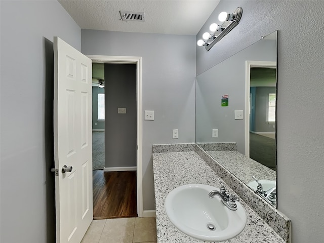 422 Magnolia Way, League City, TX 77573 - bathroom featuring tile patterned floors, healthy amount of natural light, vanity, a textured ceiling, and baseboards