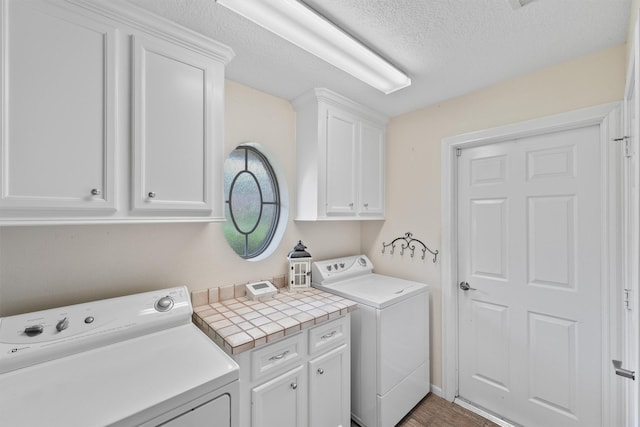 6981 Leisure Ln, Willis, TX 77318 - laundry area featuring cabinet space, washer and clothes dryer, and a textured ceiling