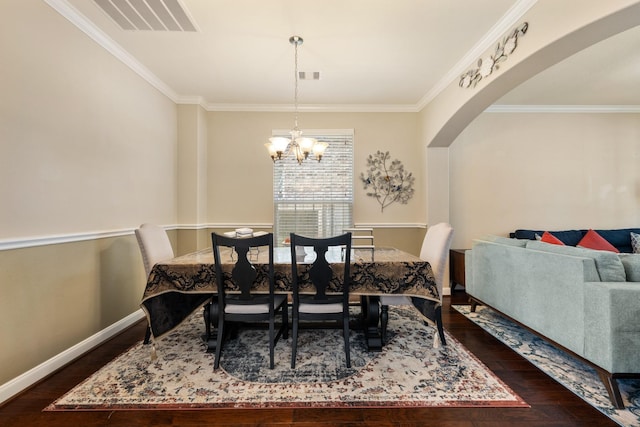 25611 Kearsley Dr, Katy, TX 77494 - dining area with arched walkways, dark wood-style floors, a chandelier, crown molding, and baseboards