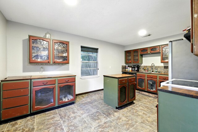 71 White Oak St, Point Blank, TX 77364 - kitchen with freestanding refrigerator, a sink, butcher block countertops, a center island, and baseboards