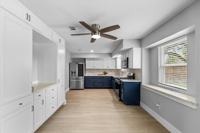 607 Mary Ann Dr, Friendswood, TX 77546 - kitchen featuring stainless steel appliances, blue cabinetry, a ceiling fan, white cabinetry, and light countertops