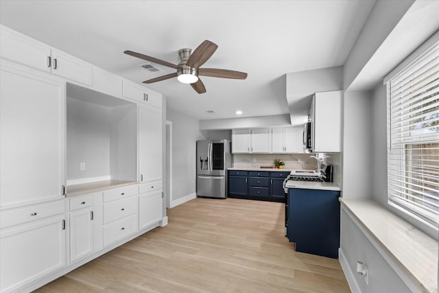 607 Mary Ann Dr, Friendswood, TX 77546 - kitchen featuring appliances with stainless steel finishes, blue cabinetry, white cabinets, a ceiling fan, and light countertops