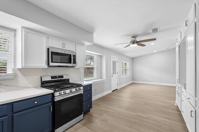 607 Mary Ann Dr, Friendswood, TX 77546 - kitchen with stainless steel appliances, blue cabinets, ceiling fan, white cabinetry, and recessed lighting