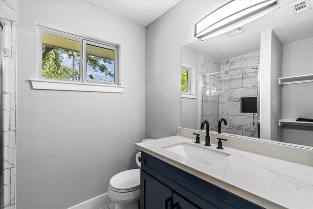 607 Mary Ann Dr, Friendswood, TX 77546 - bathroom featuring vanity, toilet, a marble finish shower, and baseboards