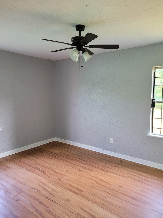 5754 Belarbor St, Houston, TX 77033 - empty room with light wood-type flooring, a ceiling fan, a textured wall, and baseboards