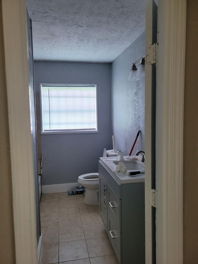 5754 Belarbor St, Houston, TX 77033 - bathroom with toilet, vanity, tile patterned floors, a textured ceiling, and baseboards