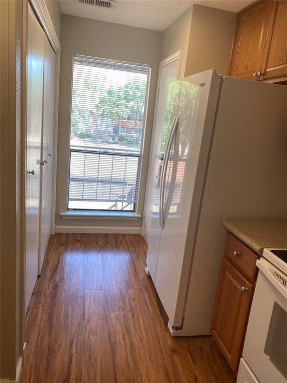 8435 Sands Point Dr, Houston, TX 77036 - kitchen featuring wood finished floors, brown cabinetry, white electric range oven, and light countertops
