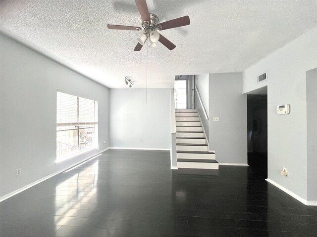 3754 Tanglewilde St Unit 9, Houston, TX 77063 - unfurnished living room with a textured ceiling, stairway, a ceiling fan, and baseboards