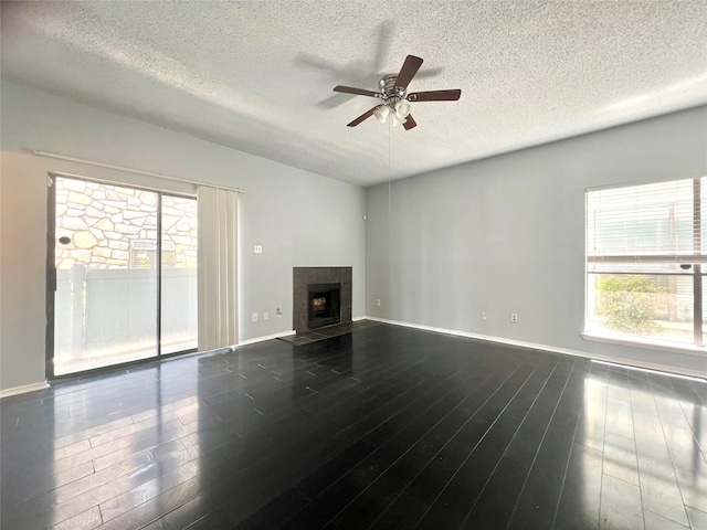 3754 Tanglewilde St Unit 9, Houston, TX 77063 - unfurnished living room with a textured ceiling, a ceiling fan, plenty of natural light, a tile fireplace, and dark wood finished floors