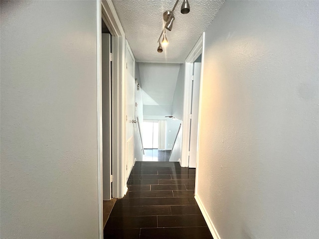 3754 Tanglewilde St Unit 9, Houston, TX 77063 - hall with a textured ceiling, rail lighting, wood finished floors, and baseboards
