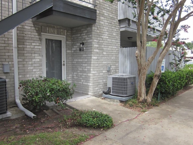 9797 Leawood Blvd Unit 1411, Houston, TX 77099 - view of exterior entry featuring brick siding and central AC