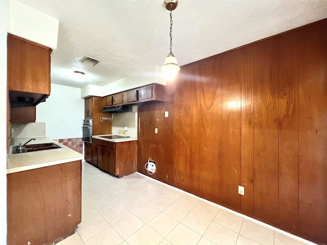 4306 Rosebud Dr, Houston, TX 77053 - kitchen with oven, light countertops, a sink, a textured ceiling, and wood walls