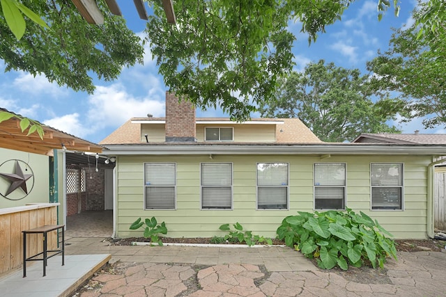 2218 Cherry Ln, Pasadena, TX 77502 - rear view of house with a patio area, a shingled roof, and a chimney