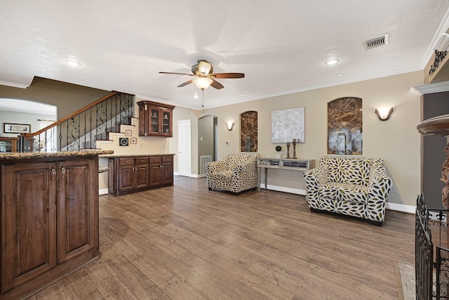 2218 Cherry Ln, Pasadena, TX 77502 - living room with arched walkways, ceiling fan, dark wood-type flooring, ornamental molding, and stairway