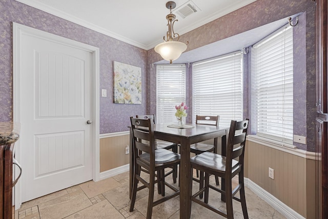 2218 Cherry Ln, Pasadena, TX 77502 - dining area featuring crown molding, plenty of natural light, a wainscoted wall, stone tile floors, and baseboards