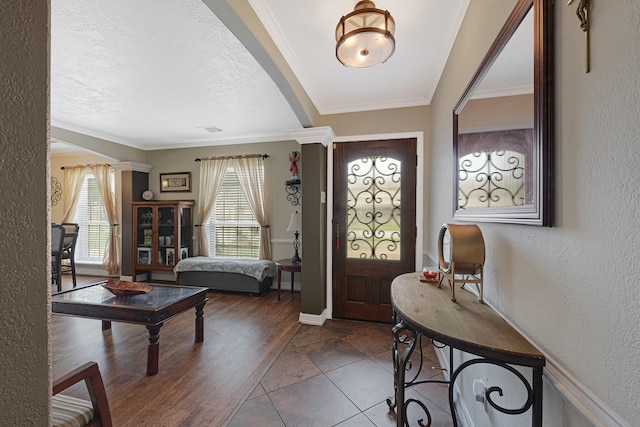2218 Cherry Ln, Pasadena, TX 77502 - foyer entrance with plenty of natural light, a textured wall, a textured ceiling, crown molding, and baseboards