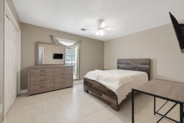 2218 Cherry Ln, Pasadena, TX 77502 - bedroom with a closet, baseboards, a textured ceiling, ceiling fan, and light tile patterned floors