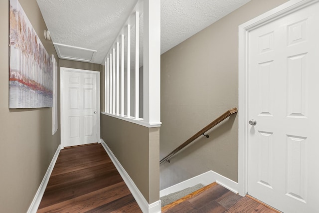 2218 Cherry Ln, Pasadena, TX 77502 - stairs featuring wood finished floors, baseboards, attic access, and a textured ceiling