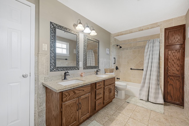 2218 Cherry Ln, Pasadena, TX 77502 - bathroom featuring shower / tub combo with curtain, double vanity, toilet, tile walls, and a wainscoted wall