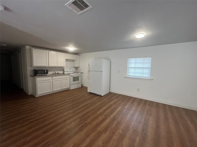 4416 Quitman St, Houston, TX 77026 - kitchen featuring white appliances, dark wood finished floors, baseboards, and white cabinetry