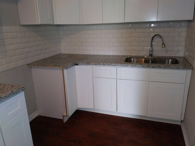2152 William Tell St, Houston, TX 77093 - kitchen featuring a sink, dark wood-style floors, light stone counters, white cabinetry, and tasteful backsplash