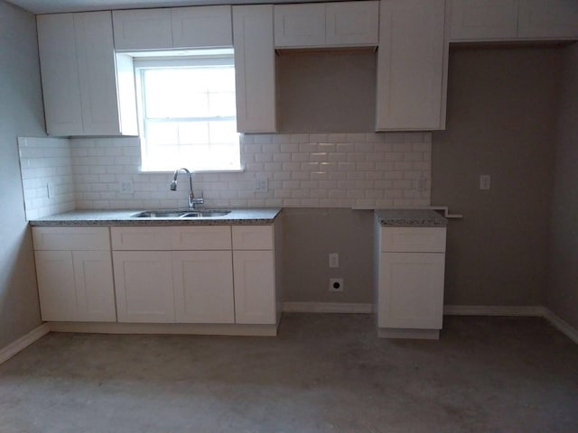 2152 William Tell St, Houston, TX 77093 - kitchen featuring a sink, baseboards, decorative backsplash, and white cabinets