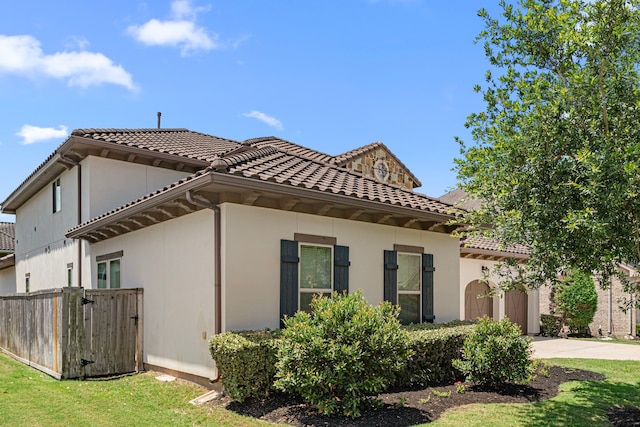 6407 Caparra Rock Ln, Sugar Land, TX 77479 - view of side of property featuring driveway, a tiled roof, stucco siding, and a garage