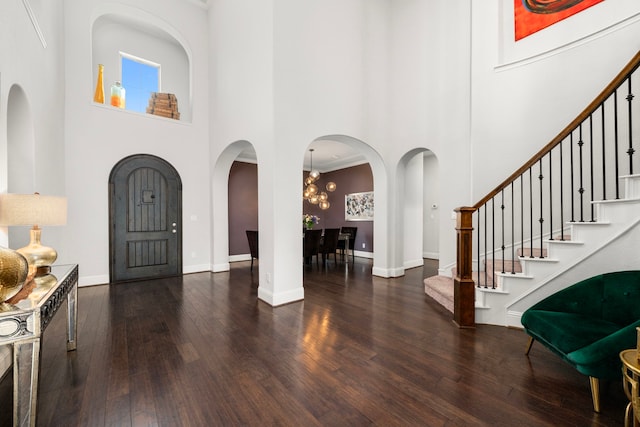 6407 Caparra Rock Ln, Sugar Land, TX 77479 - foyer with a high ceiling, wood finished floors, stairs, arched walkways, and baseboards
