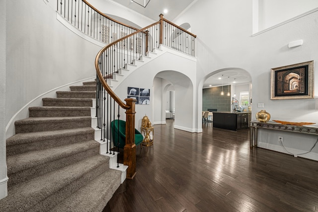 6407 Caparra Rock Ln, Sugar Land, TX 77479 - foyer entrance with arched walkways, a high ceiling, wood finished floors, stairway, and baseboards