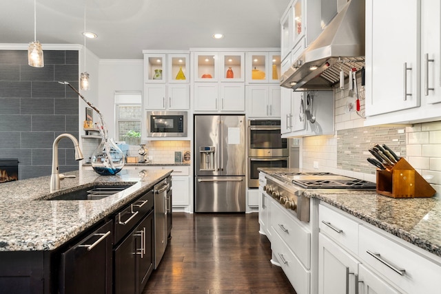 6407 Caparra Rock Ln, Sugar Land, TX 77479 - kitchen featuring stainless steel appliances, under cabinet range hood, a sink, tasteful backsplash, and white cabinets