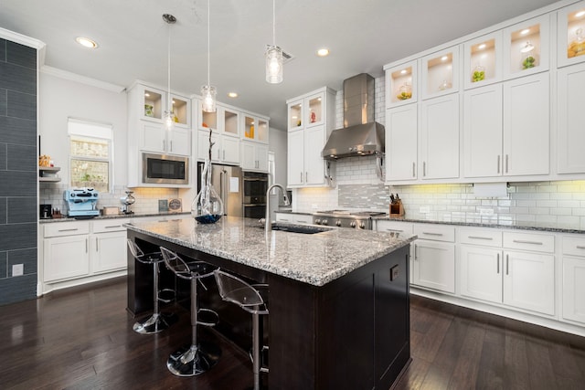 6407 Caparra Rock Ln, Sugar Land, TX 77479 - kitchen featuring wall chimney exhaust hood, a sink, appliances with stainless steel finishes, dark wood-style flooring, and backsplash
