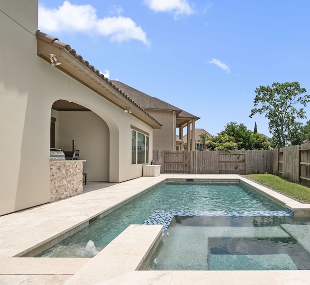 6407 Caparra Rock Ln, Sugar Land, TX 77479 - view of pool featuring exterior kitchen, a pool with connected hot tub, a fenced backyard, and a patio