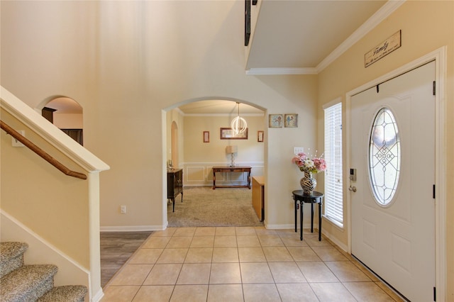 10531 Sunflower Dr, Willis, TX 77318 - foyer featuring ornamental molding, arched walkways, stairs, light colored carpet, and a high ceiling