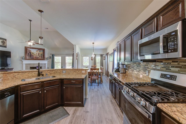10531 Sunflower Dr, Willis, TX 77318 - kitchen with stainless steel appliances, a sink, light wood-style flooring, and light stone countertops