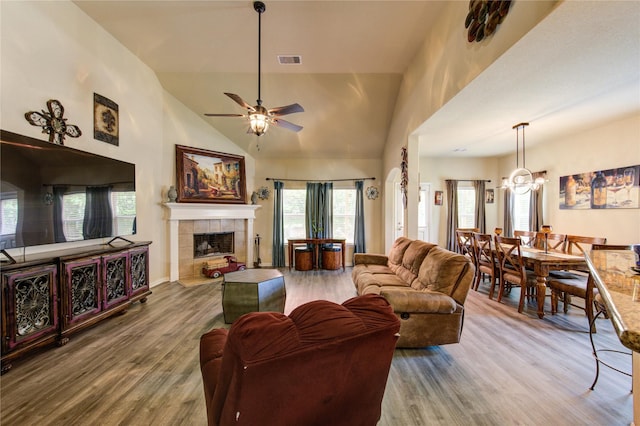 10531 Sunflower Dr, Willis, TX 77318 - living room featuring wood finished floors, ceiling fan, a tile fireplace, high vaulted ceiling, and baseboards