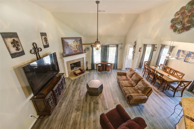 10531 Sunflower Dr, Willis, TX 77318 - living room with wood finished floors, a tiled fireplace, a ceiling fan, and high vaulted ceiling