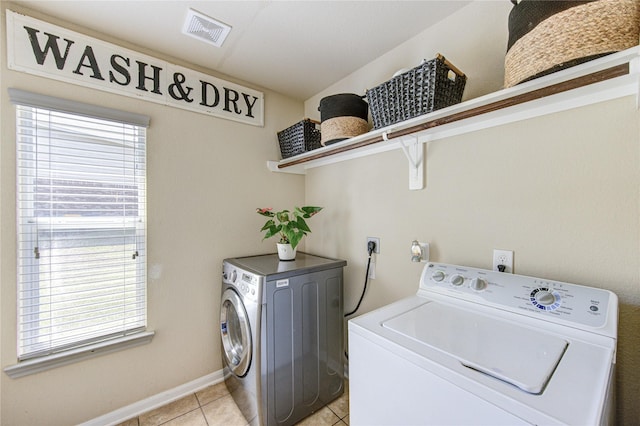 10531 Sunflower Dr, Willis, TX 77318 - washroom featuring washing machine and dryer, healthy amount of natural light, light tile patterned floors, and baseboards