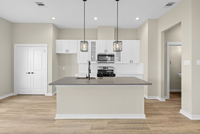 11326 Stonework Grove Ln, Houston, TX 77076 - kitchen with appliances with stainless steel finishes, white cabinetry, a sink, baseboards, and light wood finished floors
