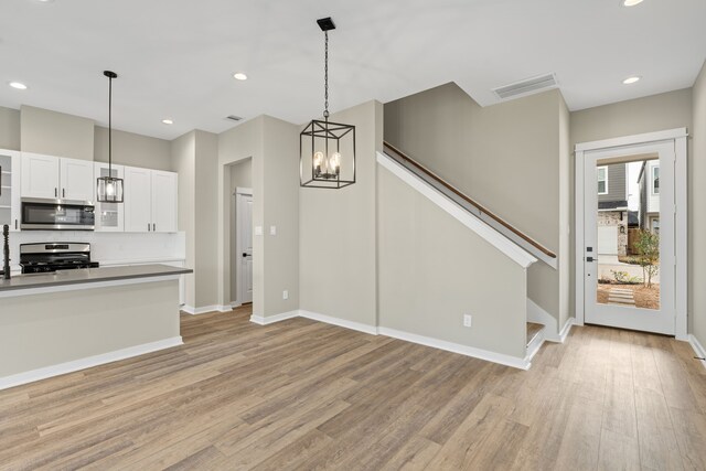 11326 Stonework Grove Ln, Houston, TX 77076 - kitchen with stainless steel appliances, light wood-type flooring, a chandelier, baseboards, and recessed lighting