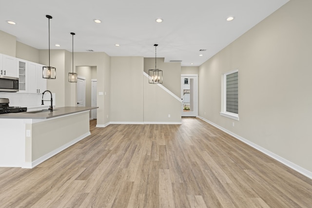 11326 Stonework Grove Ln, Houston, TX 77076 - kitchen with appliances with stainless steel finishes, a sink, light wood-type flooring, white cabinets, and recessed lighting