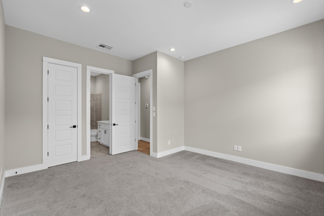 1139 W 22nd St, Houston, TX 77008 - unfurnished bedroom featuring light carpet, baseboards, recessed lighting, and connected bathroom